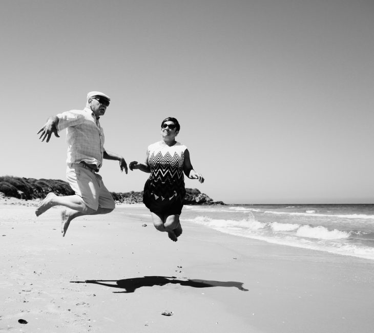Couple de seniors sautant sur la plage
