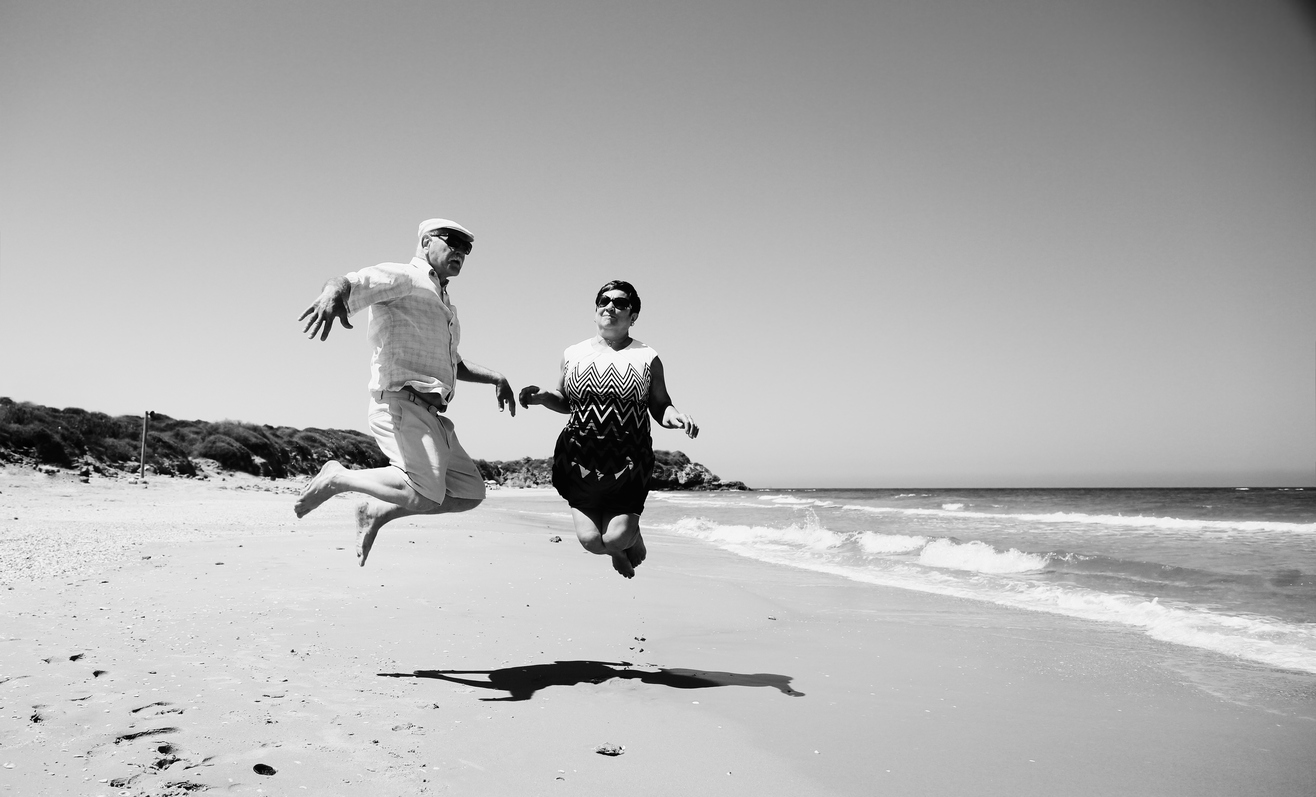 Accompagnement de seniors Couple de seniors sautant sur la plage